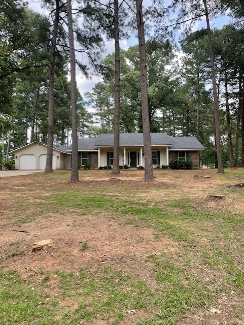 3841 Meyers St, Shreveport, LA 71119 - rear view of property with a chimney, a lawn, and stone siding