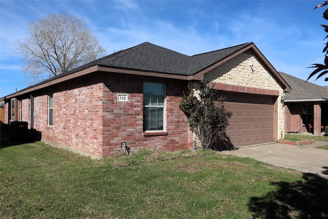 view of side of home featuring driveway, an attached garage, brick siding, and a yard
