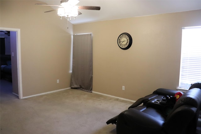 interior space with light carpet, baseboards, and a ceiling fan