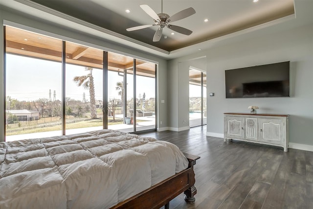 bedroom featuring dark wood-style flooring, baseboards, access to outside, and a raised ceiling