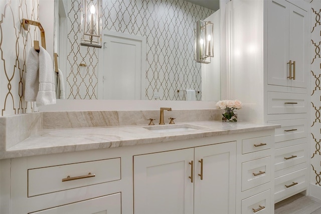 full bath with wallpapered walls and vanity