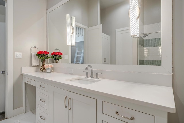 bathroom featuring tile patterned flooring, tiled shower, and vanity