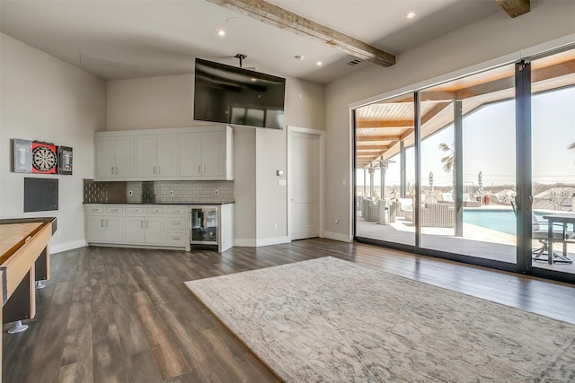 interior space with visible vents, baseboards, dark wood finished floors, beamed ceiling, and beverage cooler