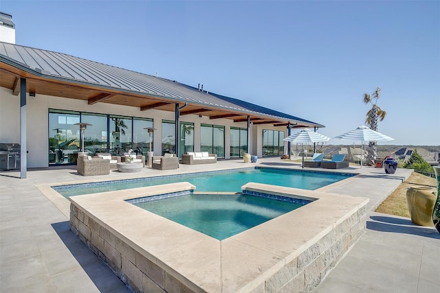 view of swimming pool with outdoor lounge area, grilling area, a patio area, and a pool with connected hot tub