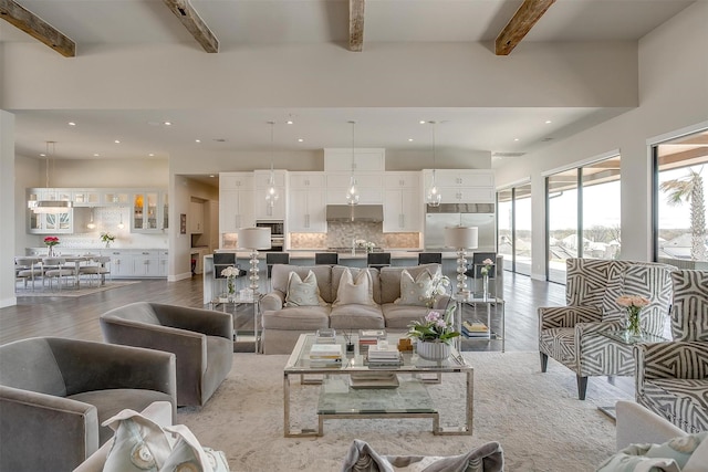 living area featuring recessed lighting, beamed ceiling, and wood finished floors