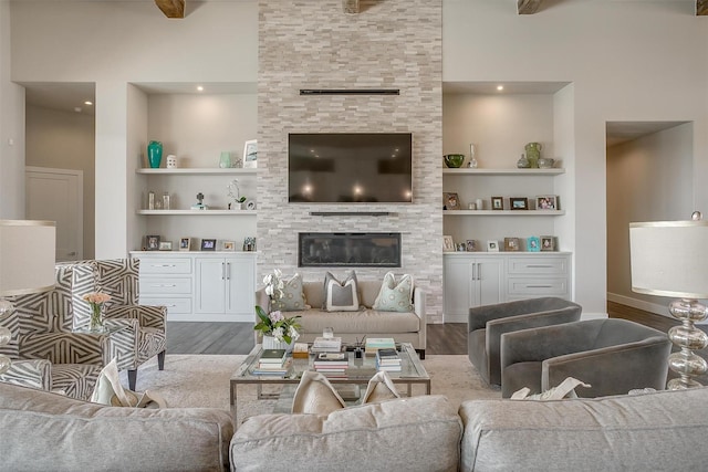 living room featuring built in shelves, wood finished floors, and a fireplace