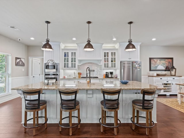 141 County Road 3481, Paradise, TX 76073 - kitchen with decorative backsplash, white cabinetry, a large island with sink, and stainless steel appliances