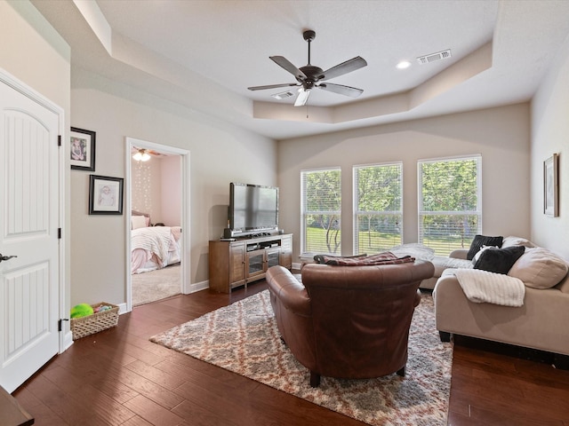 141 County Road 3481, Paradise, TX 76073 - living area featuring a tray ceiling, dark wood-style flooring, visible vents, baseboards, and ceiling fan