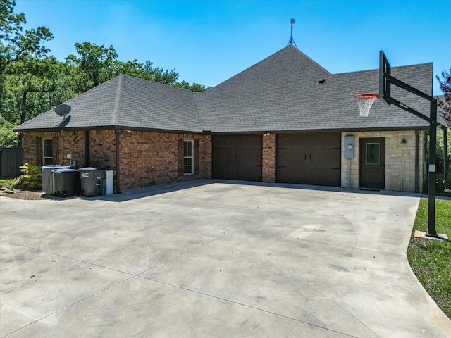 141 County Road 3481, Paradise, TX 76073 - rear view of house with brick siding, an attached garage, roof with shingles, and driveway
