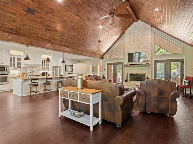 141 County Road 3481, Paradise, TX 76073 - living area featuring high vaulted ceiling, a ceiling fan, wood ceiling, a fireplace, and dark wood-type flooring