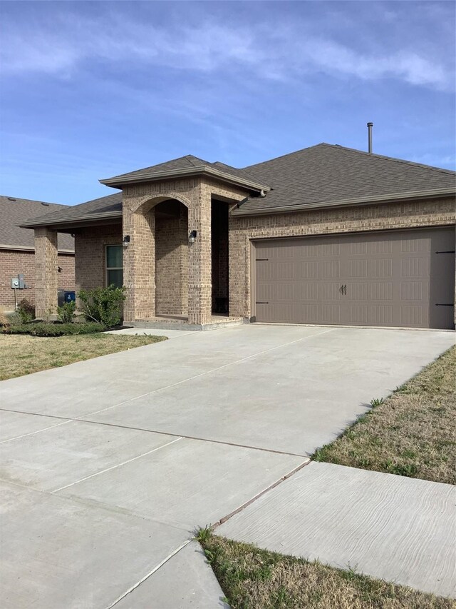156 Hawksbill Ln, Rhome, TX 76078 - prairie-style home with driveway, a shingled roof, a garage, and brick siding