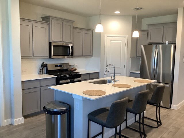 156 Hawksbill Ln, Rhome, TX 76078 - kitchen featuring gray cabinets, a sink, appliances with stainless steel finishes, light wood-type flooring, and visible vents