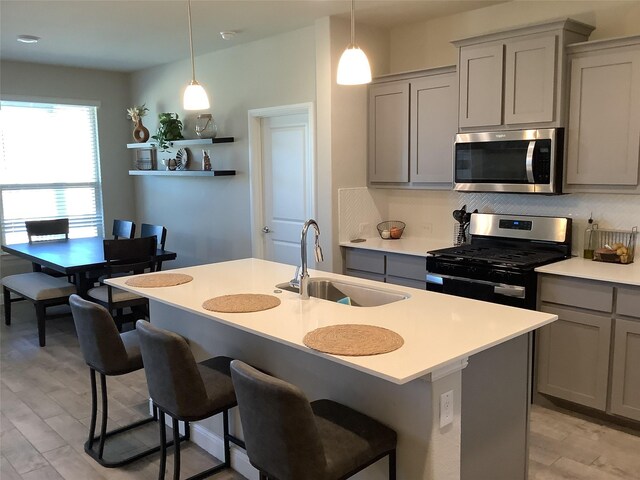 156 Hawksbill Ln, Rhome, TX 76078 - kitchen featuring light countertops, tasteful backsplash, stainless steel appliances, gray cabinetry, and a sink