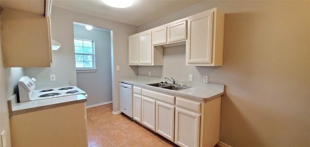kitchen with light countertops, white appliances, baseboards, white cabinetry, and a sink