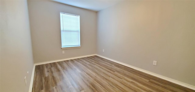 unfurnished room featuring baseboards and wood finished floors