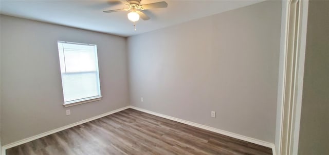 empty room with baseboards, dark wood-style flooring, and a ceiling fan