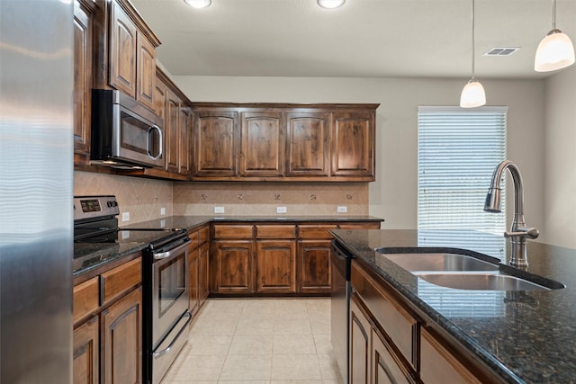 1037 Doe Meadow Dr, Fort Worth, TX 76028 - kitchen with dark stone counters, a sink, stainless steel appliances, and tasteful backsplash