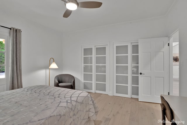 bedroom with crown molding, a ceiling fan, and wood finished floors