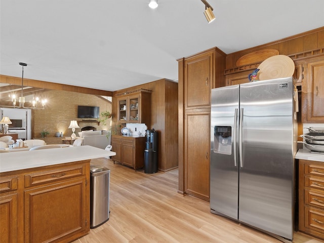 kitchen featuring light countertops, a chandelier, brown cabinets, stainless steel refrigerator with ice dispenser, and light wood-style floors