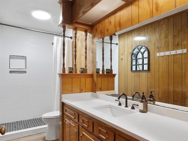 bathroom with toilet, wooden walls, vanity, and a shower with curtain