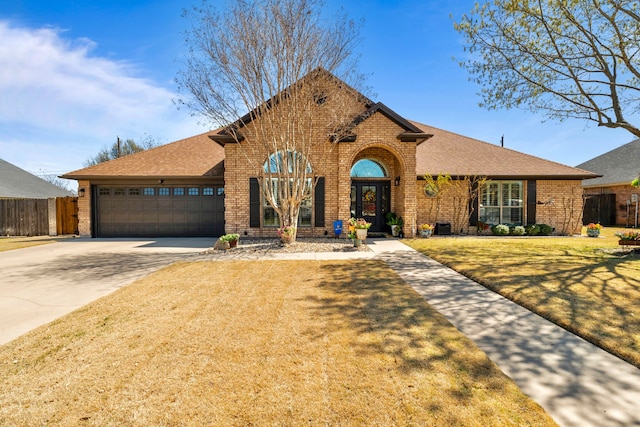 view of front of house with driveway, a shingled roof, fence, and brick siding