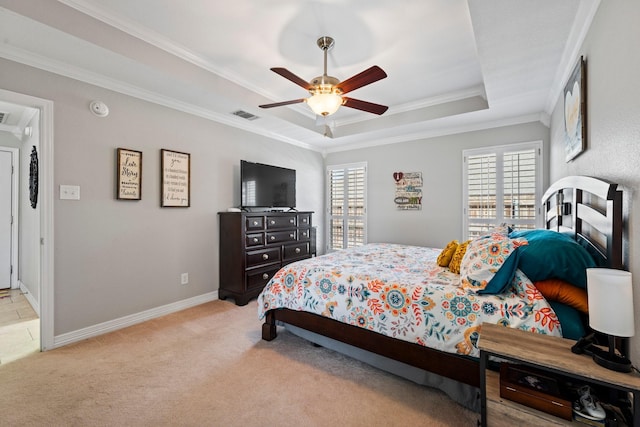 bedroom with a raised ceiling, baseboards, light colored carpet, visible vents, and ornamental molding