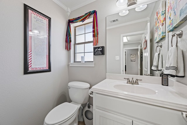 half bath with toilet, vanity, crown molding, and visible vents