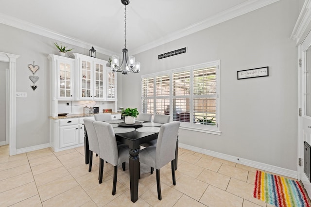 dining space featuring baseboards, ornamental molding, light tile patterned floors, and a chandelier