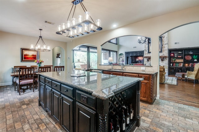 kitchen with arched walkways, brick floor, a sink, and visible vents