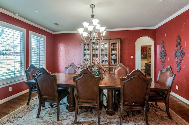 dining room with wood finished floors, visible vents, arched walkways, baseboards, and a notable chandelier