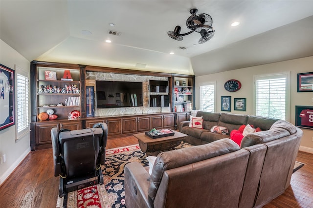 living room with dark wood-type flooring, vaulted ceiling, visible vents, and baseboards