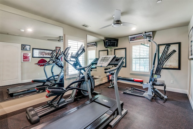 workout area featuring plenty of natural light, a ceiling fan, visible vents, and baseboards