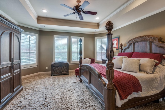 bedroom with a tray ceiling, crown molding, and baseboards