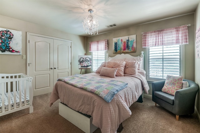 bedroom with carpet floors, a chandelier, visible vents, and a closet