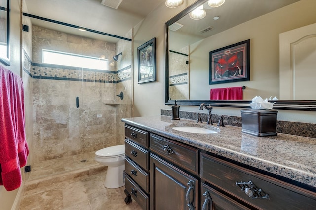 bathroom with vanity, visible vents, a shower stall, and toilet