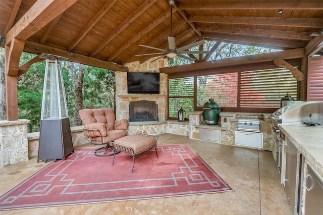view of patio / terrace featuring a gazebo, a grill, an outdoor kitchen, an outdoor stone fireplace, and ceiling fan