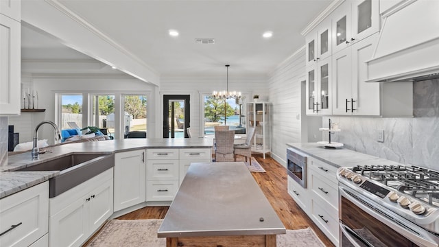 kitchen with visible vents, a chandelier, crown molding, appliances with stainless steel finishes, and a sink