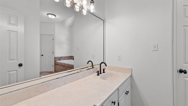 bathroom with vanity and tiled tub