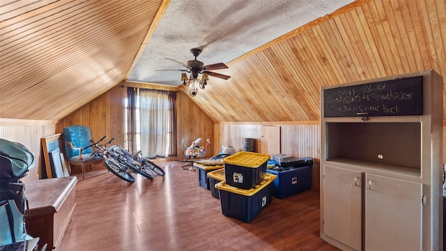 interior space featuring wooden ceiling, a ceiling fan, wood finished floors, wood walls, and lofted ceiling