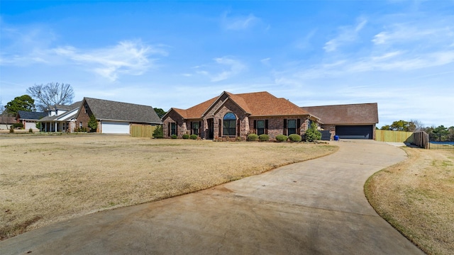 view of front of house with fence, driveway, a gate, a front yard, and brick siding