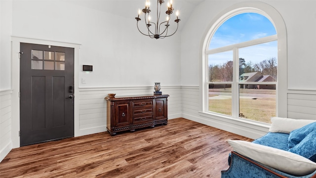 foyer entrance featuring a healthy amount of sunlight, wood finished floors, and an inviting chandelier