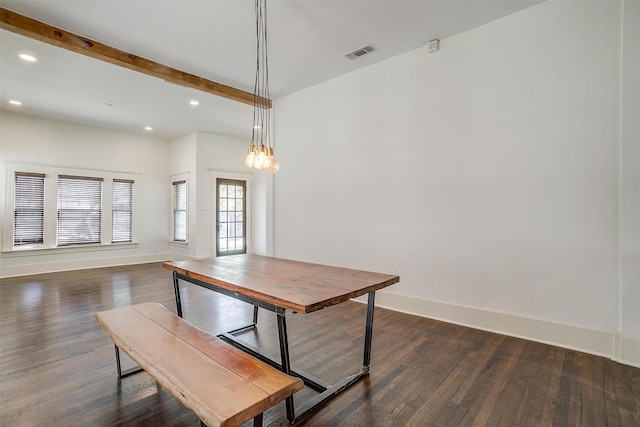 unfurnished dining area featuring dark wood finished floors, beamed ceiling, visible vents, and baseboards