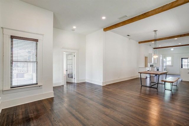 interior space with visible vents, baseboards, beamed ceiling, and wood finished floors