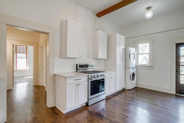 kitchen with dark wood-style flooring, light countertops, stacked washer / dryer, stainless steel range with gas cooktop, and backsplash