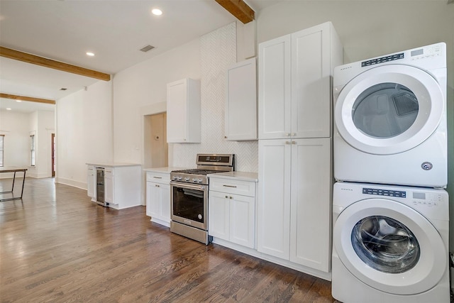 laundry area featuring dark wood-style flooring, visible vents, stacked washer / drying machine, recessed lighting, and beverage cooler
