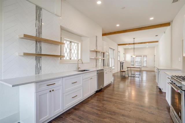kitchen featuring white cabinets, appliances with stainless steel finishes, dark wood-type flooring, a sink, and backsplash