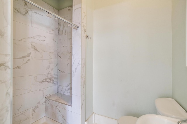 bathroom featuring toilet and tiled shower