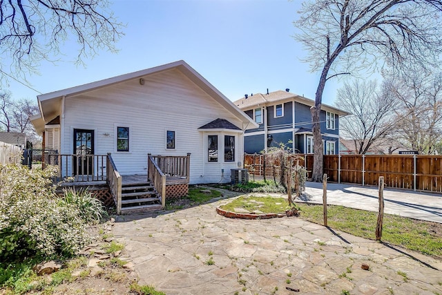 back of house with central AC unit, a wooden deck, fence, and a patio