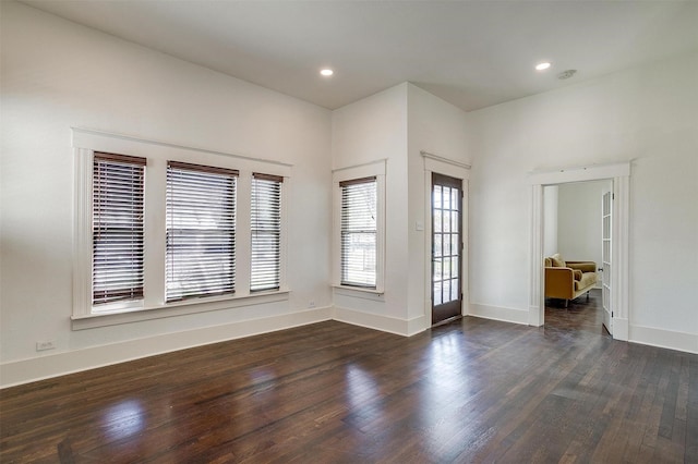 spare room with recessed lighting, baseboards, and dark wood finished floors