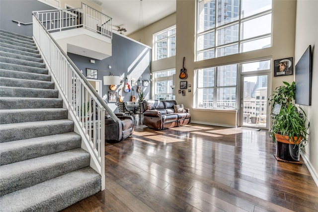 2323 N Houston St Unit 710, Dallas, TX 75219 - stairway featuring a towering ceiling, wood-type flooring, and baseboards